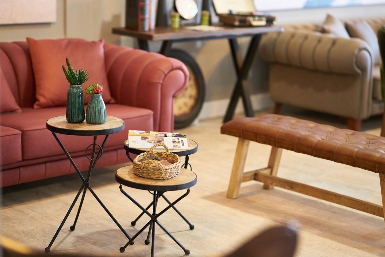 A brass desk lamp on a dark wooden table, with an address book and a vintage telephone